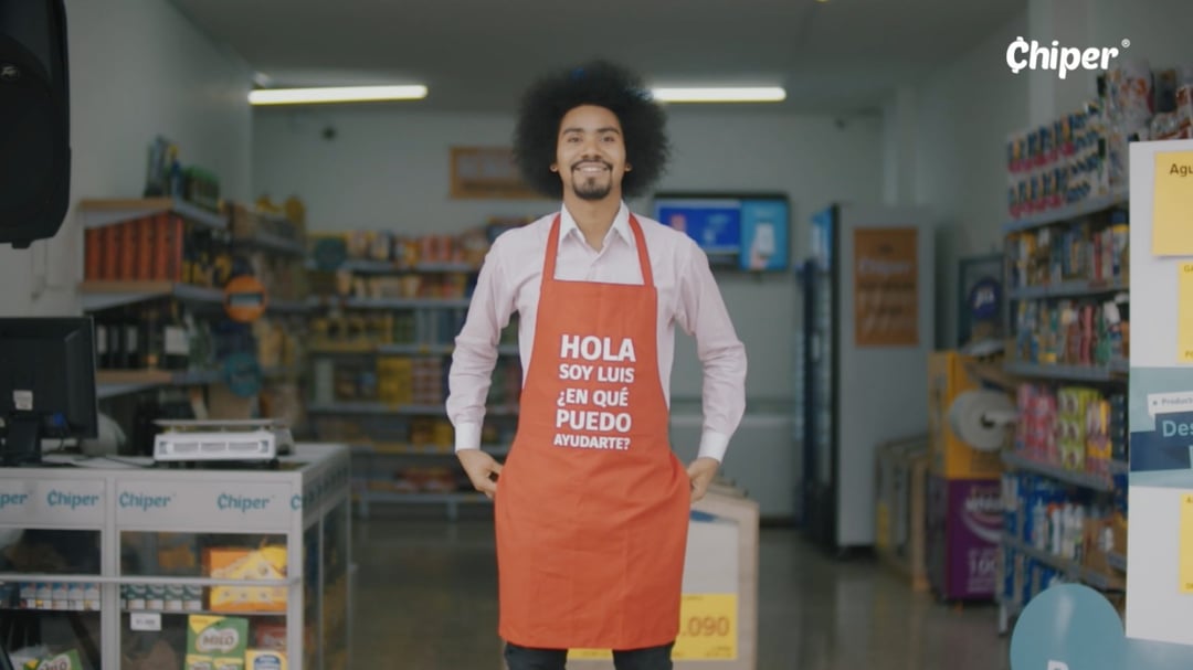 A boy wearing an orange apron with the text 