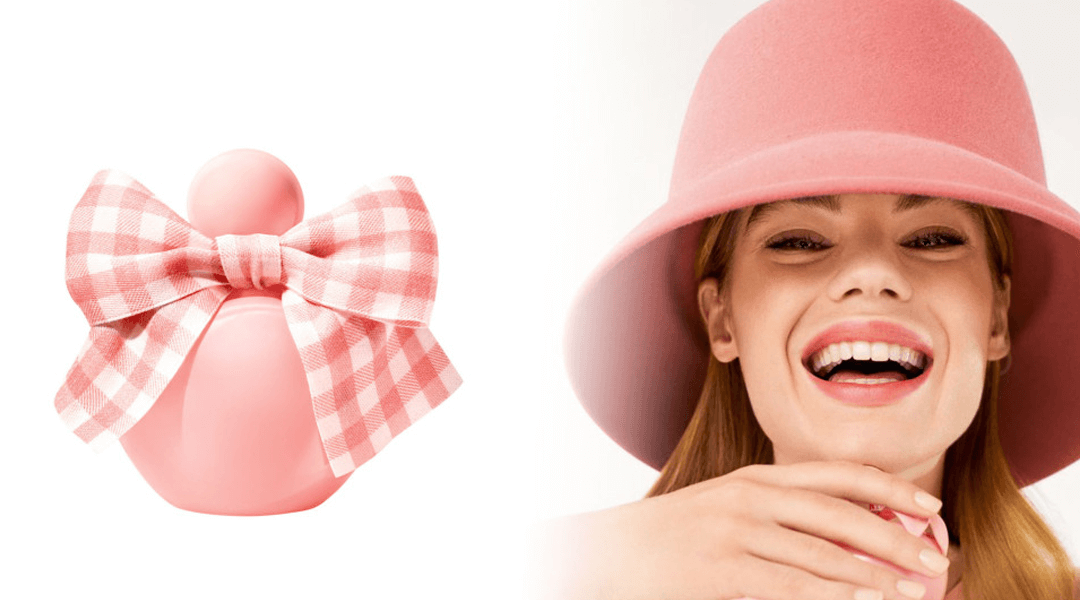 Pink Nina Ricci perfume with a bow of squares and a smiling model