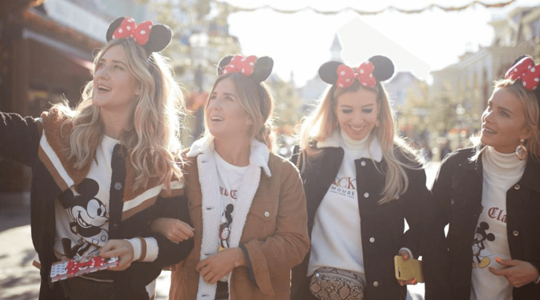 Four girls wearing different Mickey Mouse 90th anniversary x Stradivarius products.